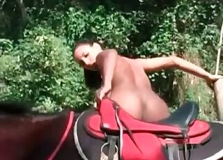 Slender chick poses naked on her stallion